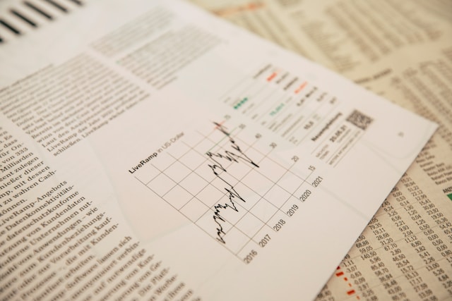 Jornal financeiro com gráfico de ações para análise econômica